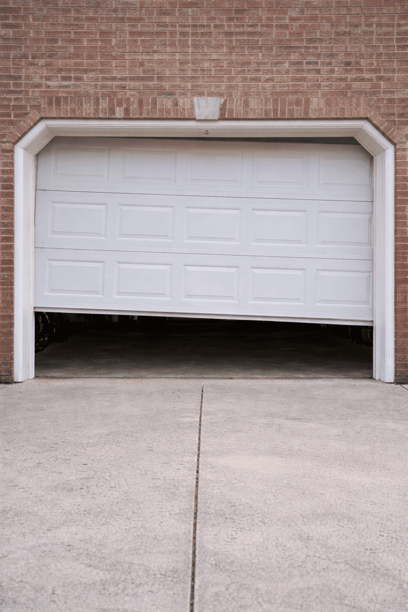 Crooked garage door indicating a broken spring