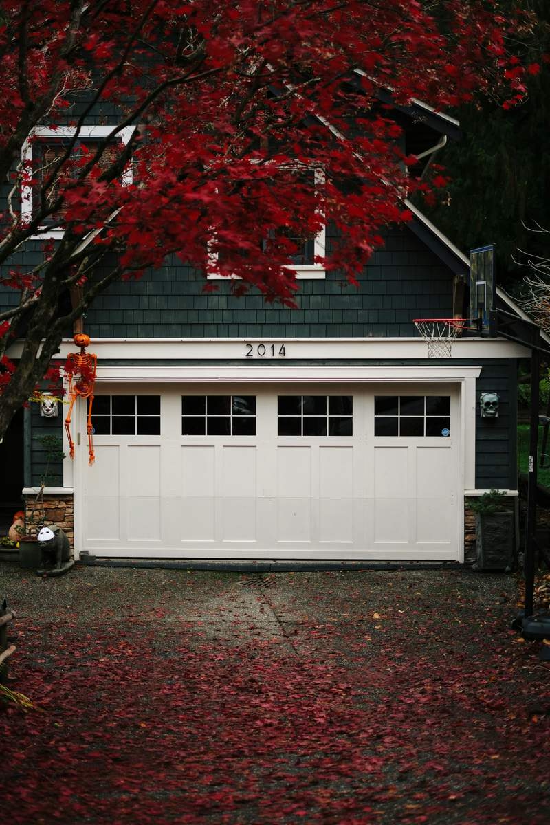 Garage door with fall leaves in front of it